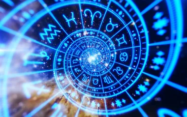 A glowing blue astrological chart with zodiac symbols arranged in a spiral against a cosmic background.