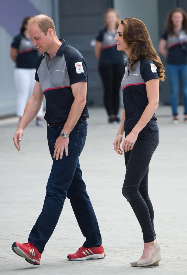 A man and woman in matching shirts walking outdoors, with others in similar attire in the background.