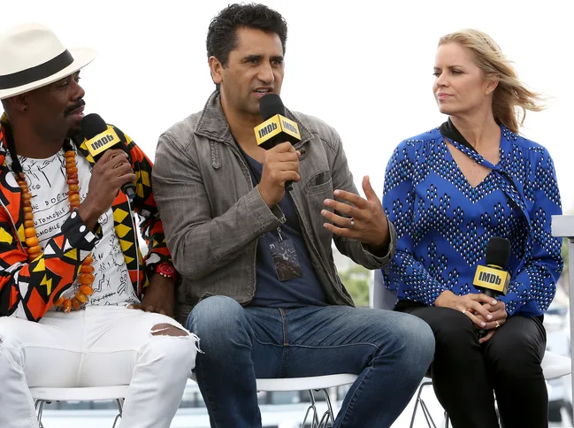 Three people sitting and talking into IMDb microphones during an outdoor event.