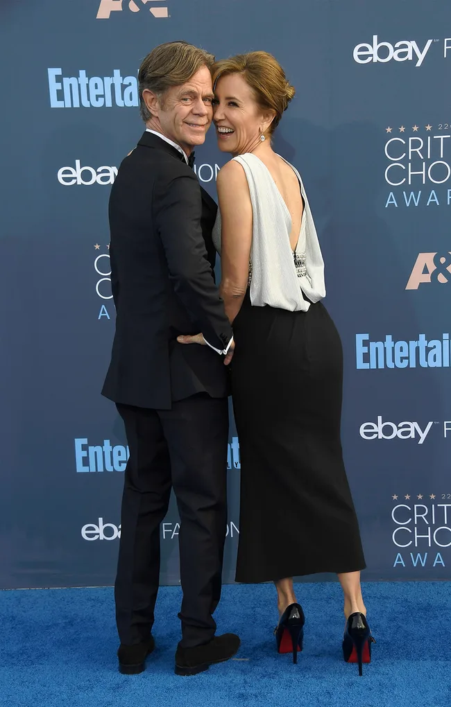 A couple poses on the blue carpet at the Critics' Choice Awards, smiling and embracing.