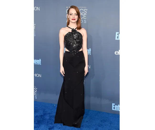 Woman in a black gown on the blue carpet at the Critics' Choice Awards.
