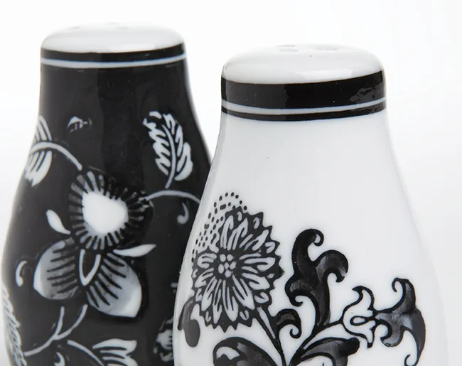 Black and white floral salt and pepper shakers on a white background.