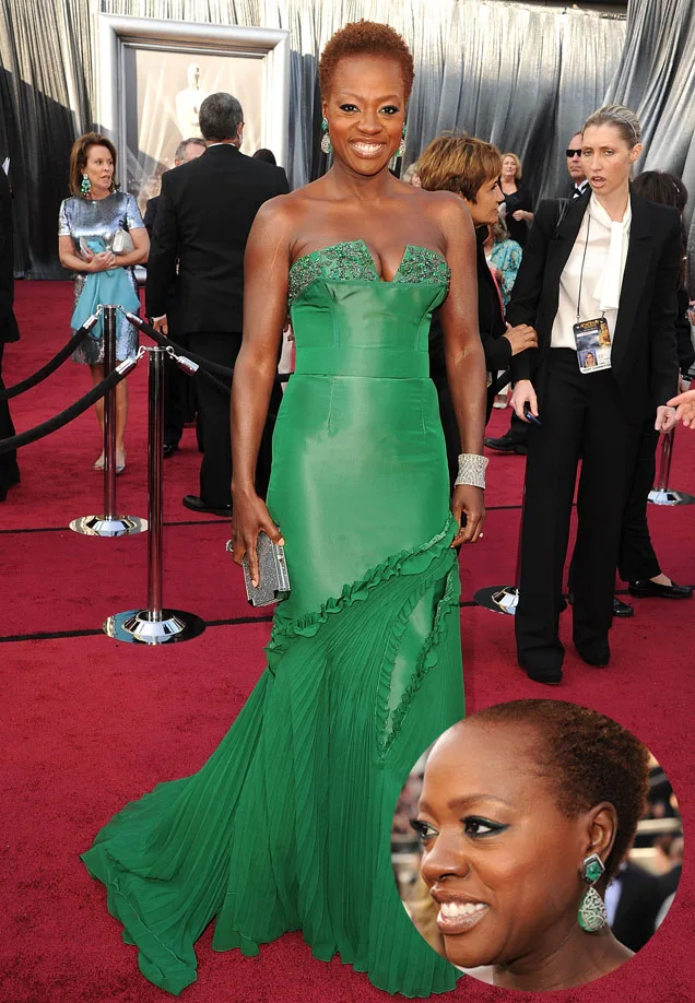 African-American woman in a green gown on a red carpet with a smiling close-up inset.