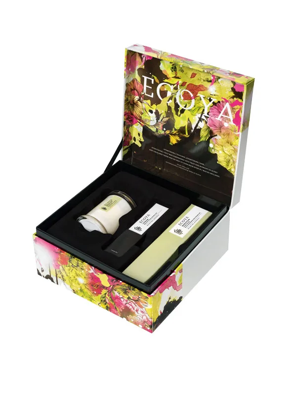 Open floral-themed Ecoya gift box with candle, reed diffuser, and fragrance bottle.