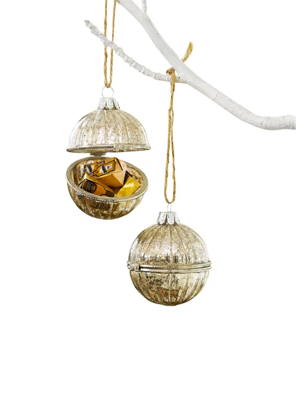 Hanging gold ornaments with one opened, revealing chocolates inside.