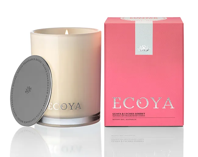 Lit Ecoya candle in glass jar with pink box labeled "Guava & Lychee Sorbet".