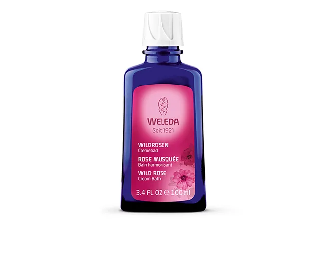 Blue bottle of Weleda Wild Rose Cream Bath, labeled in multiple languages, 100ml size.