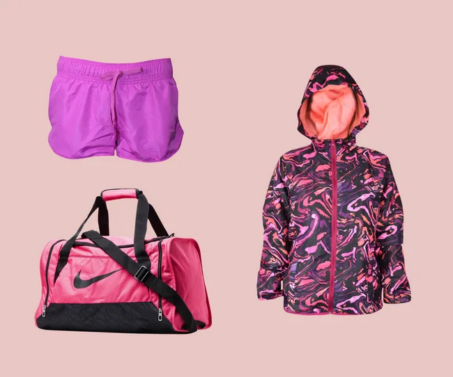 Purple shorts, pink and black Nike duffel bag, and a colorful hooded jacket on a peach background.