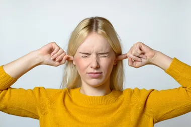 Woman blocking her ears