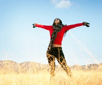 Woman in field, happy, arms outstretched