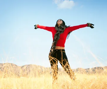 Woman in field, happy, arms outstretched