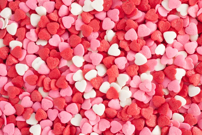 Red, pink, and white heart-shaped candies scattered randomly.