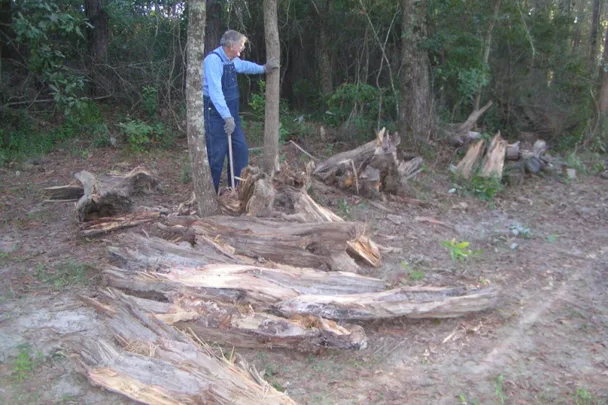 old man cutting wood for medical bills