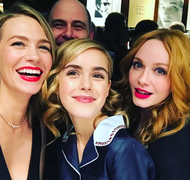 Three women pose together for a cheerful selfie at a social event.