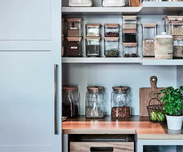 A pantry filled with glass jars and containers containing dry goods