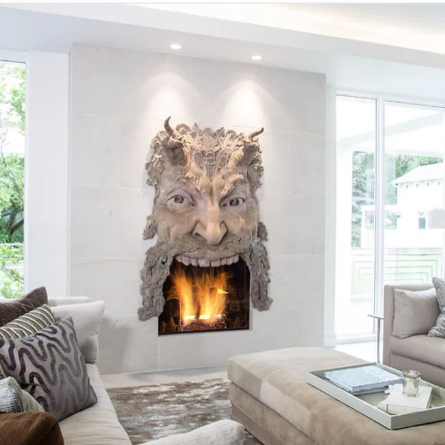 A fireplace with a large Satan head above