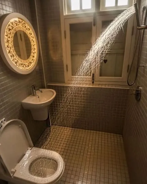 A bathroom where the shower drips into the toilet