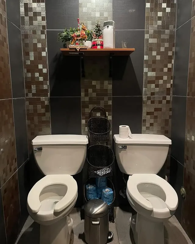 A bathroom with two toilets right next to each other