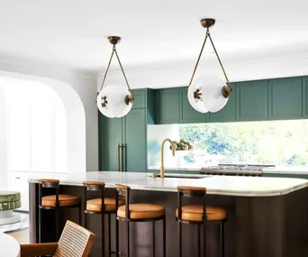 two contemporary cicular pendant lights hanging above a kitchen island.