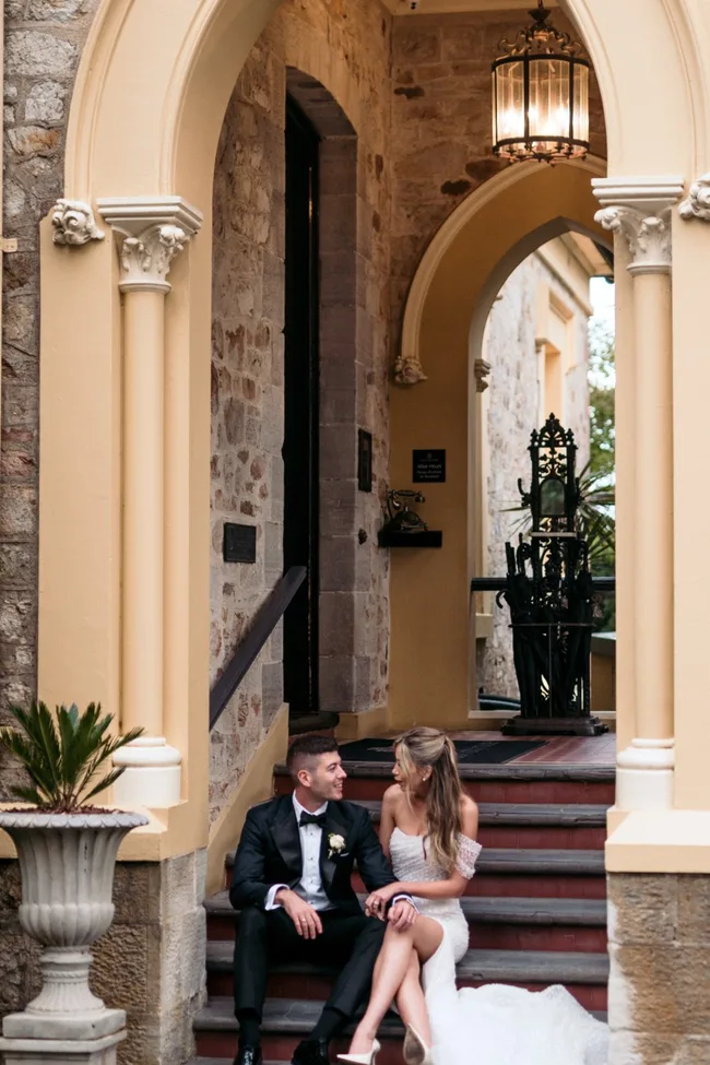 A bridge and groom on the steps of Mount Lofty House