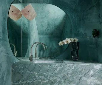 A green stone powder room with a quartz wall sconce