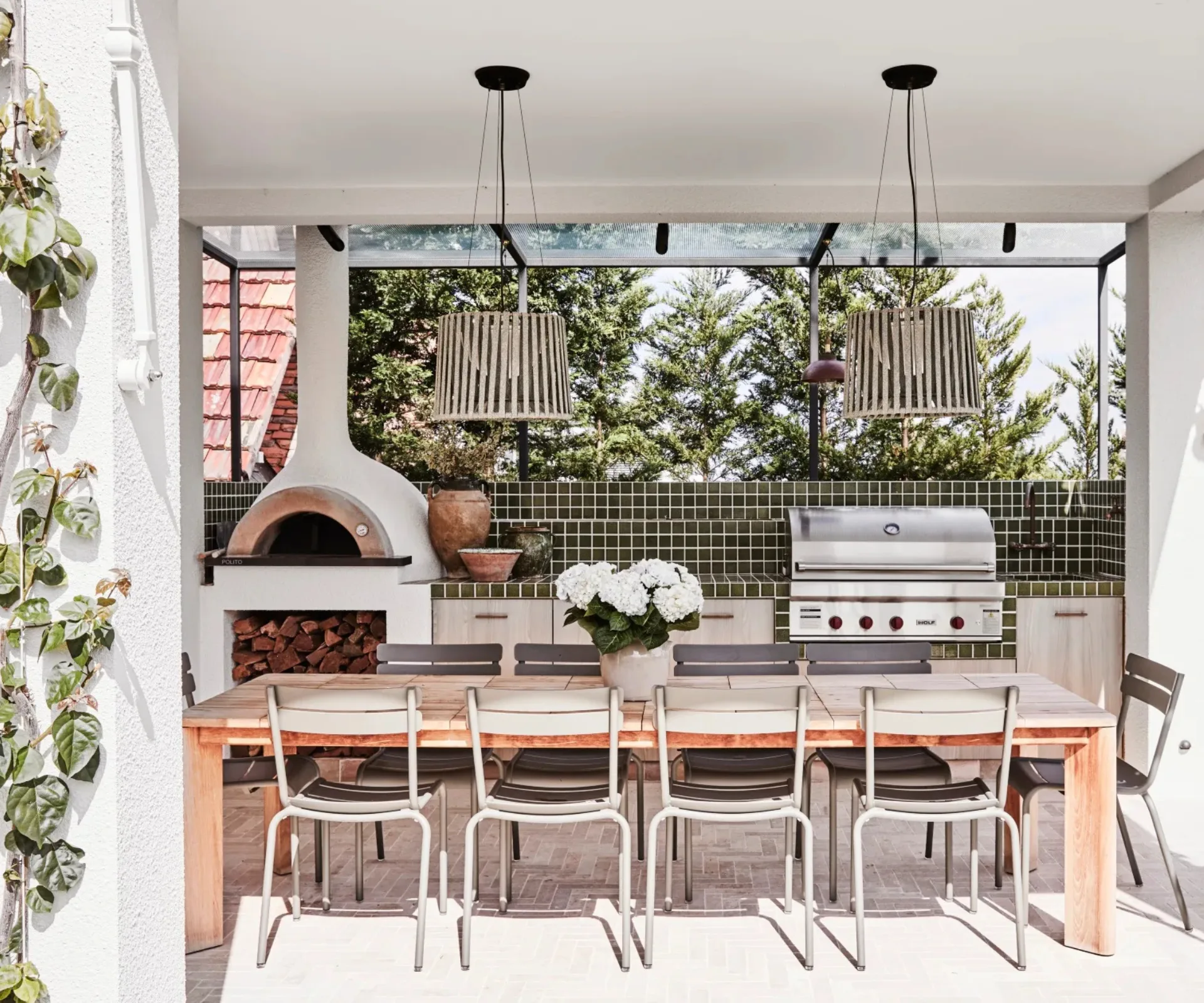 A Mediterranean-inspired alfresco dining area with a woodfire pizza oven and in-built barbecue