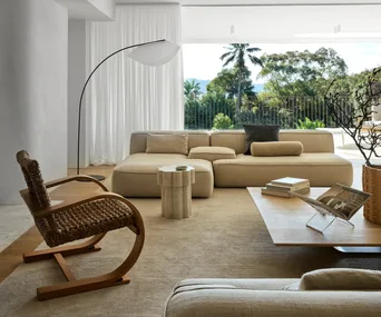 A modern Mediterranean-style living room with a large beige rug