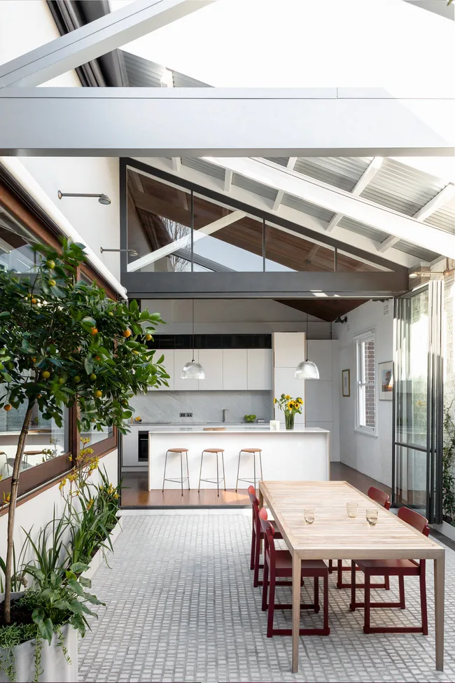 An modern kitchen sprawling out to a terrace in a renovated inner-city home