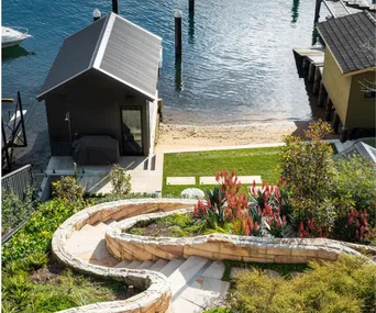 A sloping garden filled with native plants by the water