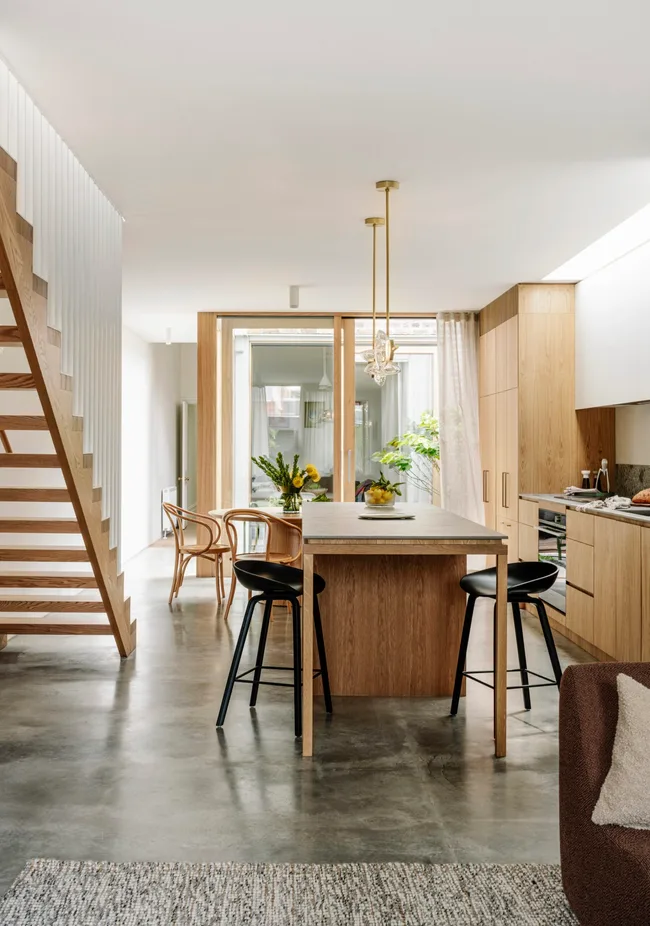 A modern kitchen with timber tones and concrete flooring