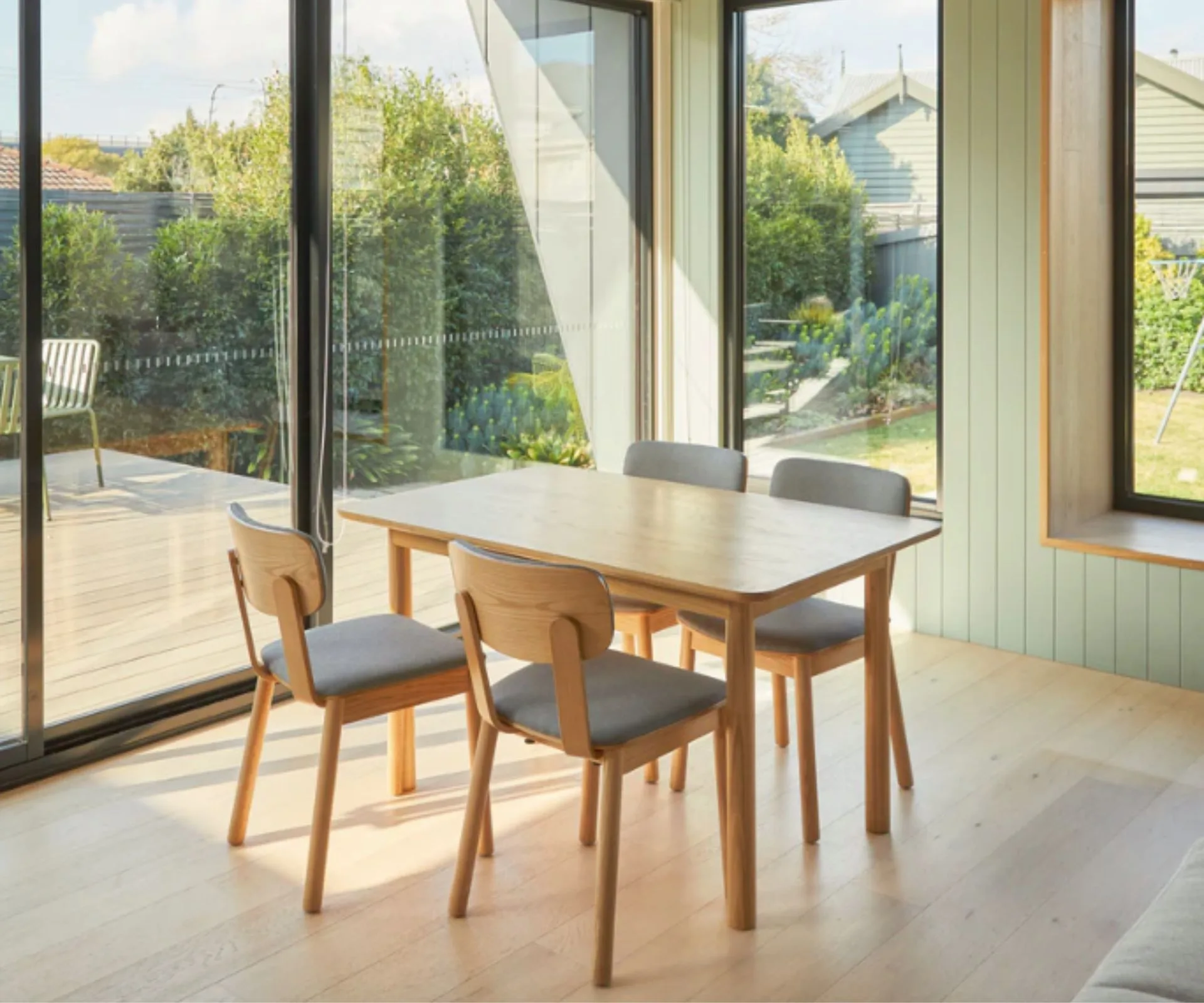 Oak dining table with four chairs in a room by a window