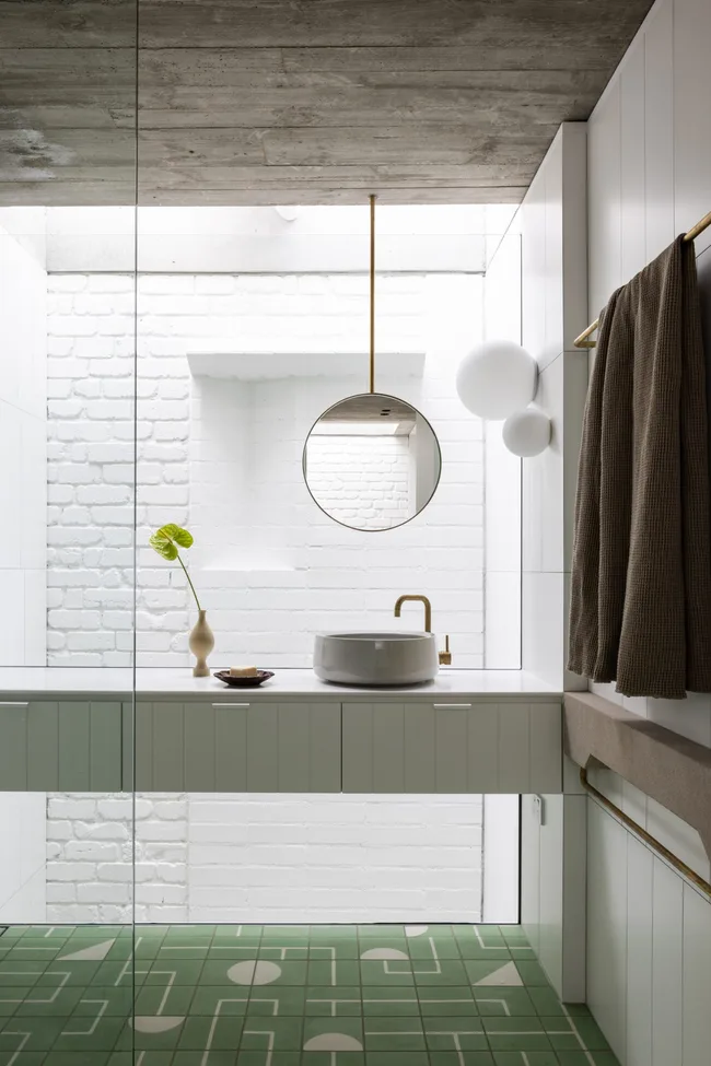 A bathroom with a floor-to-ceiling window and drop-down mirror