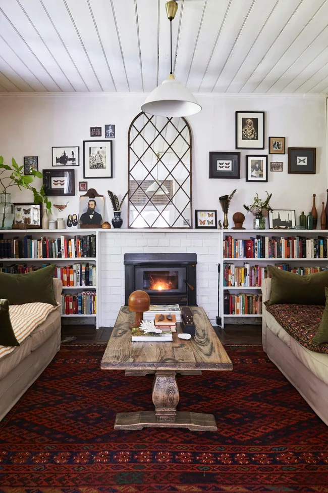 A cosy country living room with a fireplace and red rug