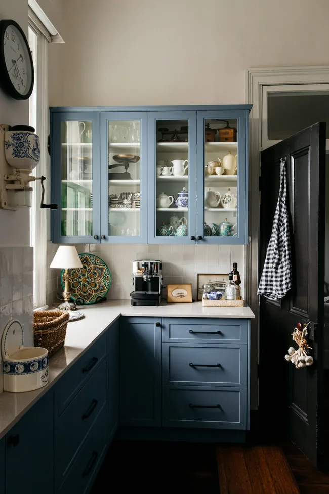 A renovated kitchen with blue cabinetry and a white Morrocan-tiled splashback