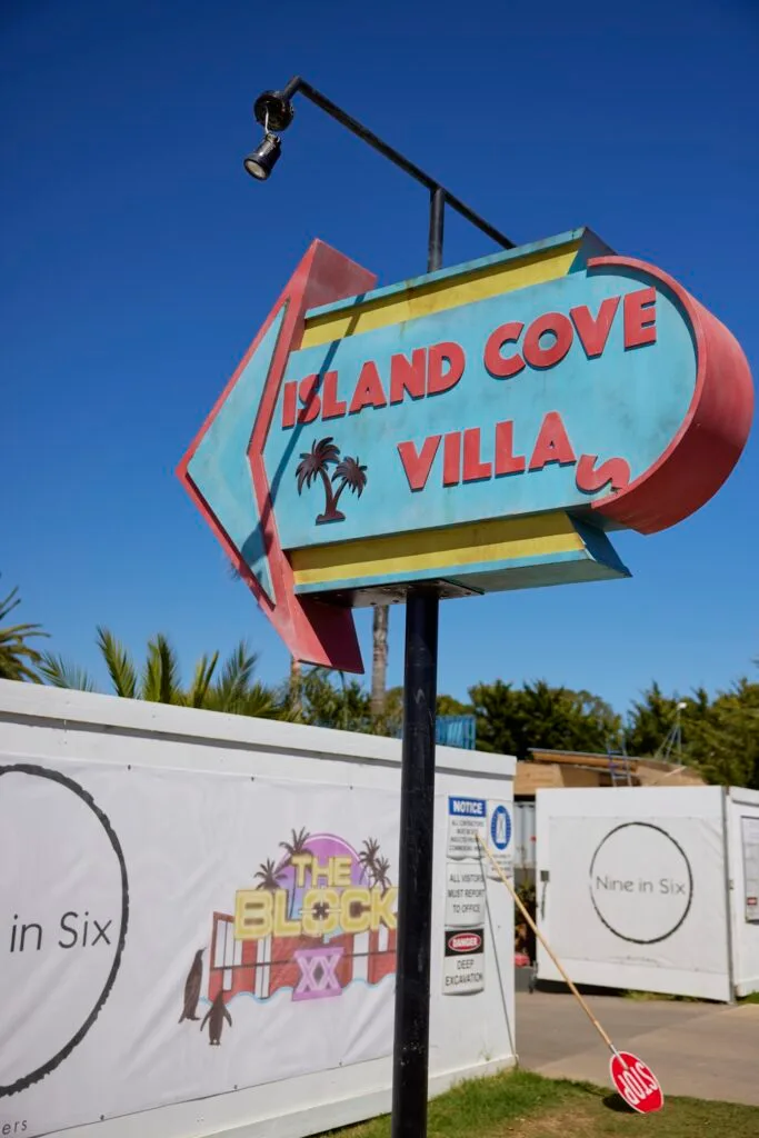 A sign reading 'Island Cove Villa' next to a truck with 'The Block' emblazoned on the side.