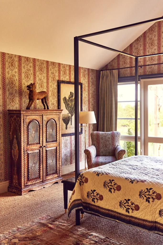 A country-style bedroom with red paisley wallpaper