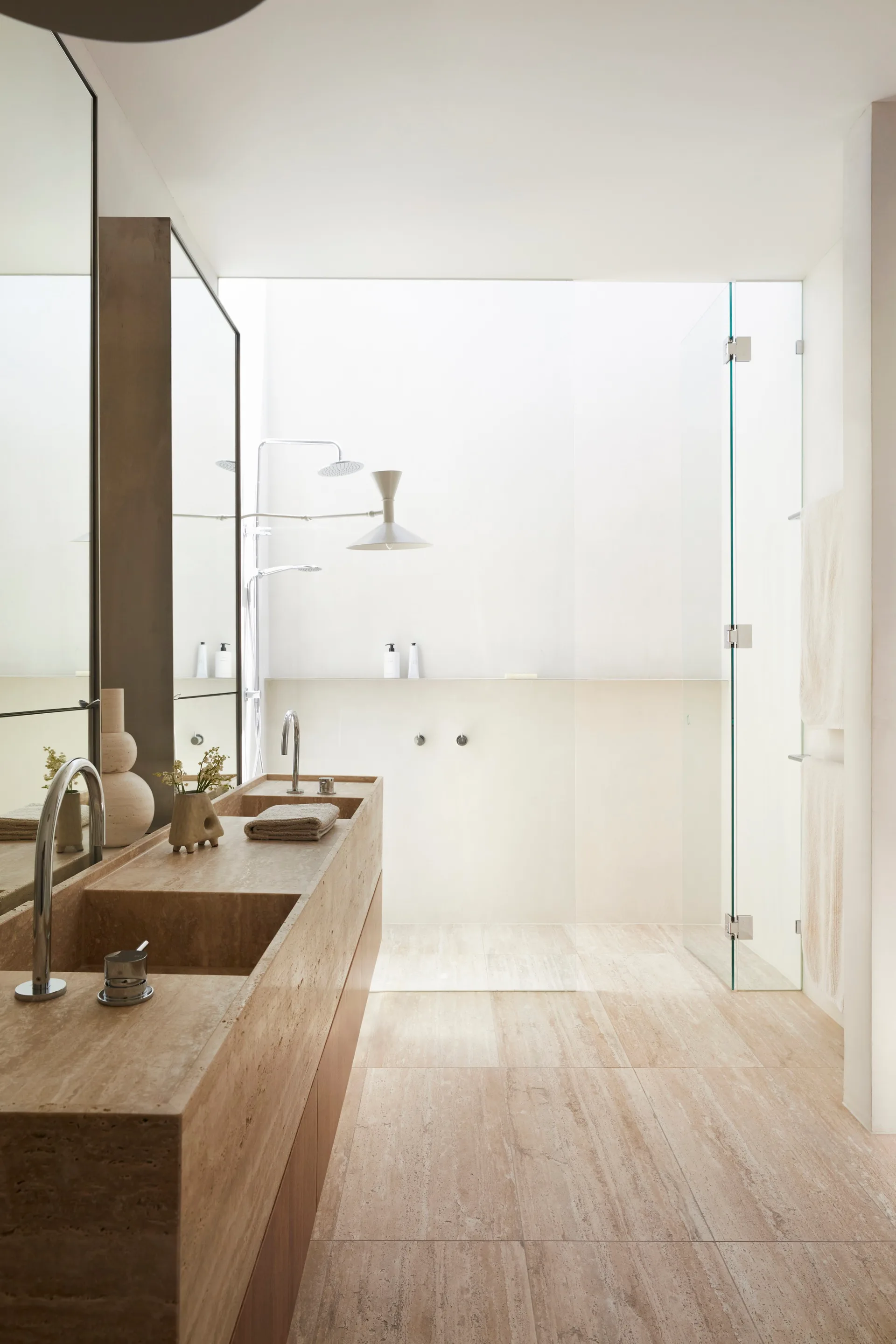 Marble bathroom with a shower illuminated by a skylight