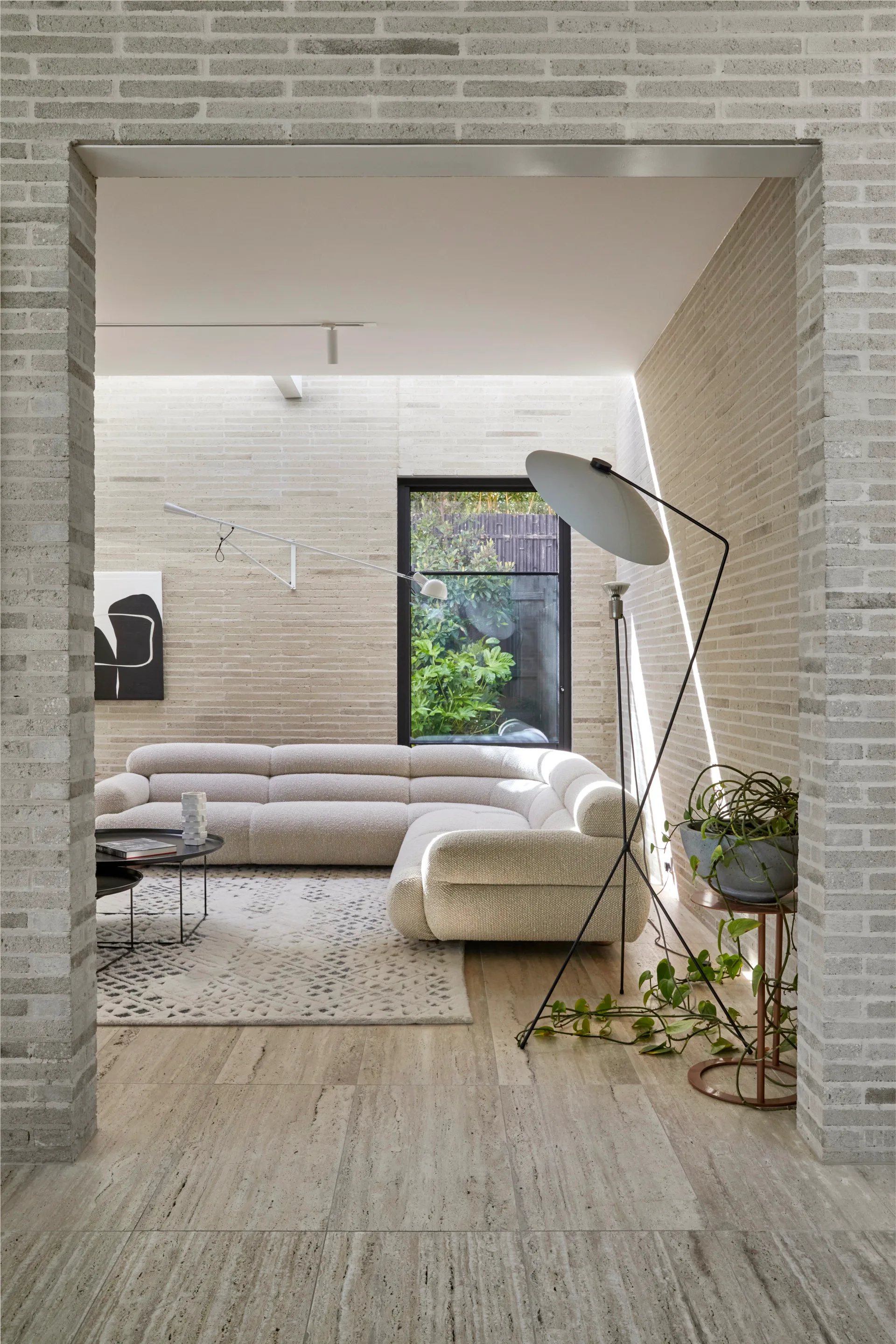 Neutral-toned living area with an L-shaped lounge and floor lamp