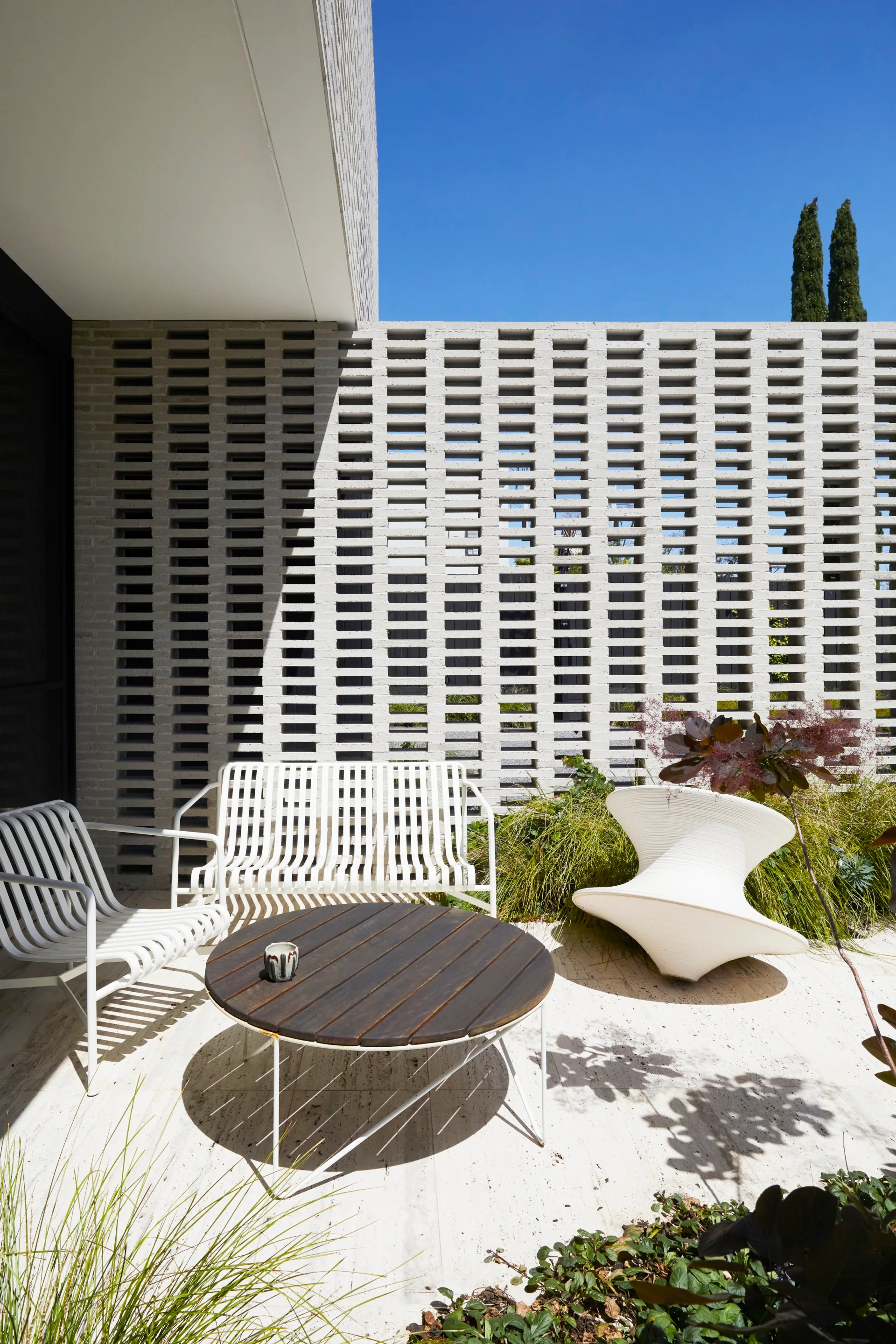 An outdoor seating area with a breezeblock wall