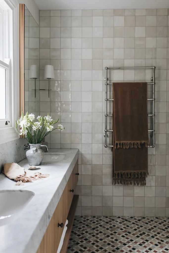 Bathroom with marble counter and beige tiled wall