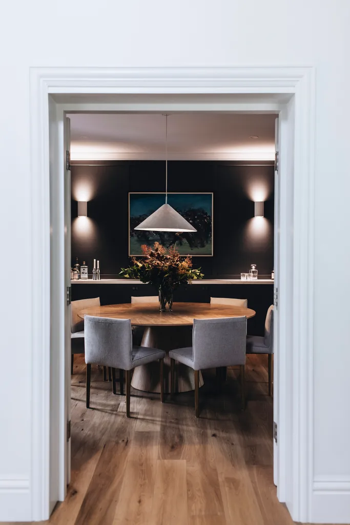 Formal dining area with a round dining table and white pendant light