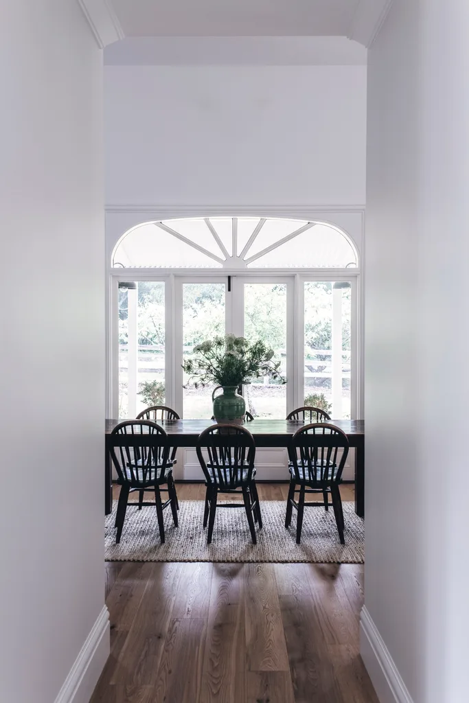 A country-style dining room with a timber dining set looking out onto the garden