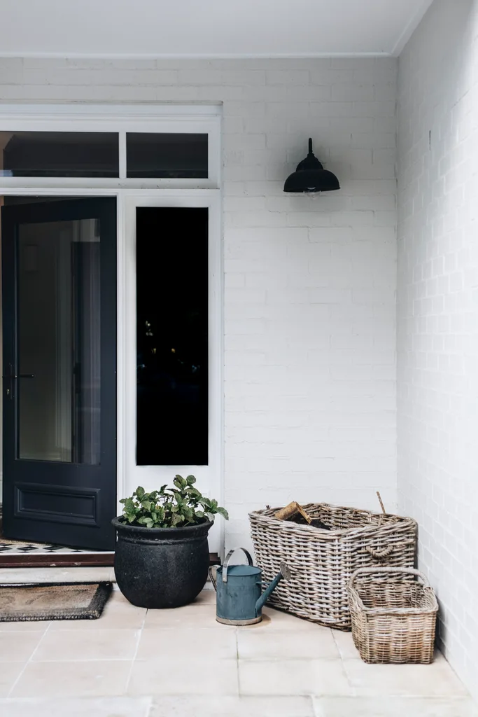 Wicker baskets and a watering can beside a front door