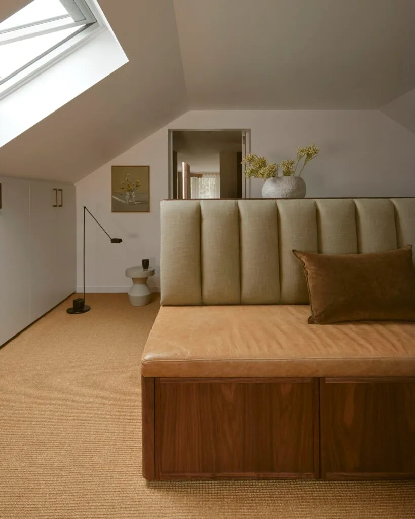 A timber and leather seat beneath a skylight