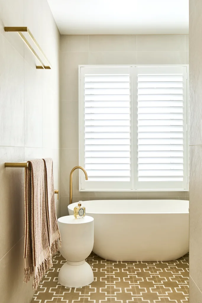 freestanding bath with gold tapware and olive floor tiles