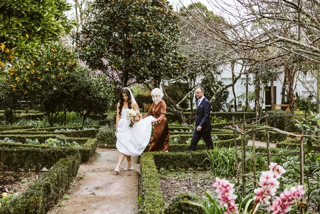 Lucy walking through a garden with her parents