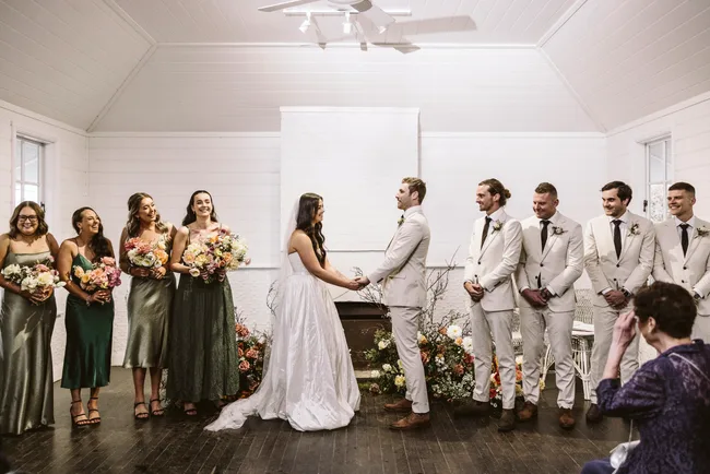 Lucy and Jack with the wedding party at the alter