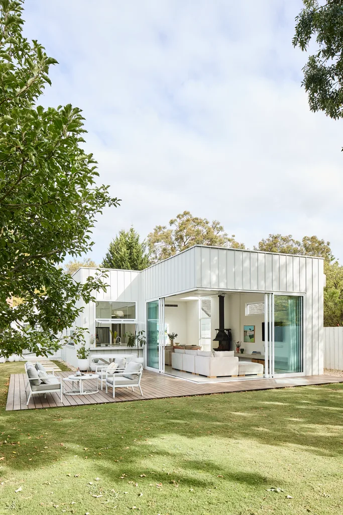 modern white home with sliding doors and a backyard