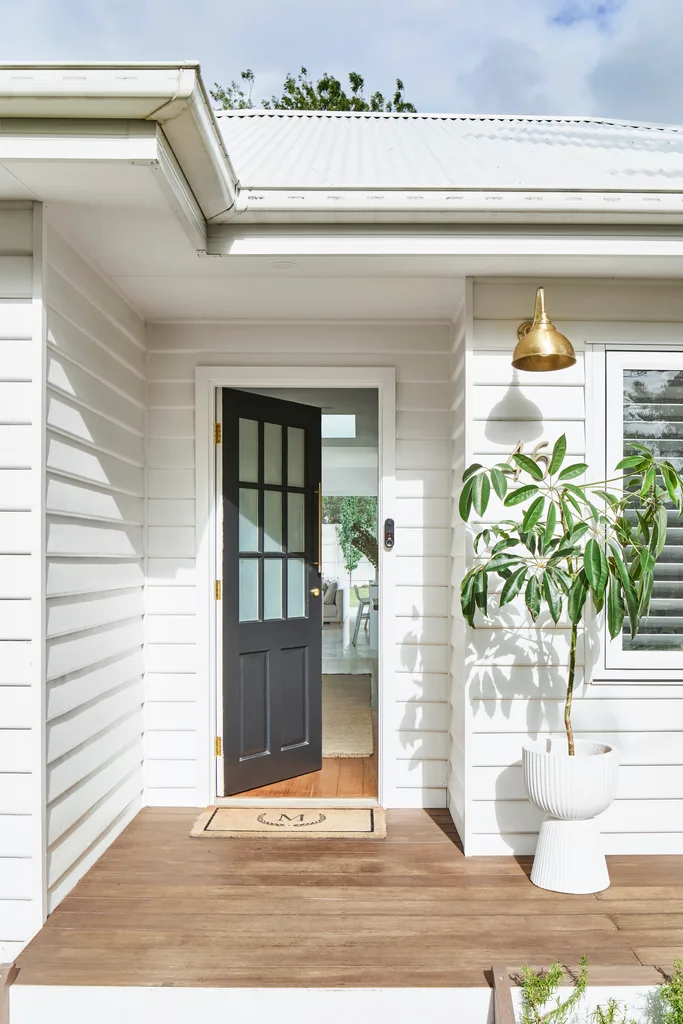 a white weatherboard home with a black front door