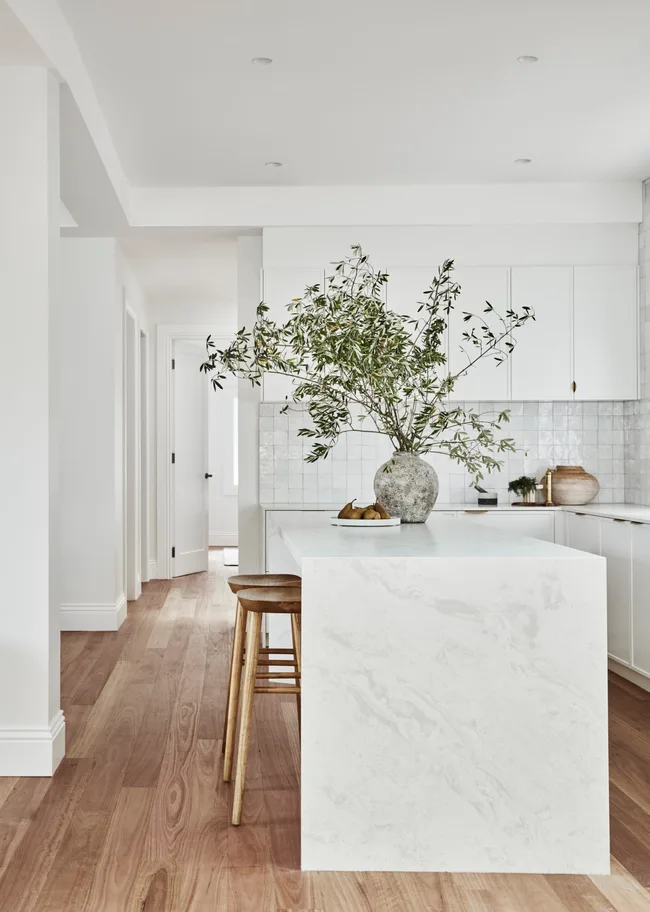 white kitchen with large stone island bench